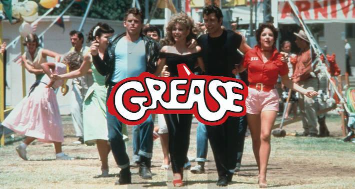 Grease film still showing characters walking while holding one another and the "Grease" logo over top.